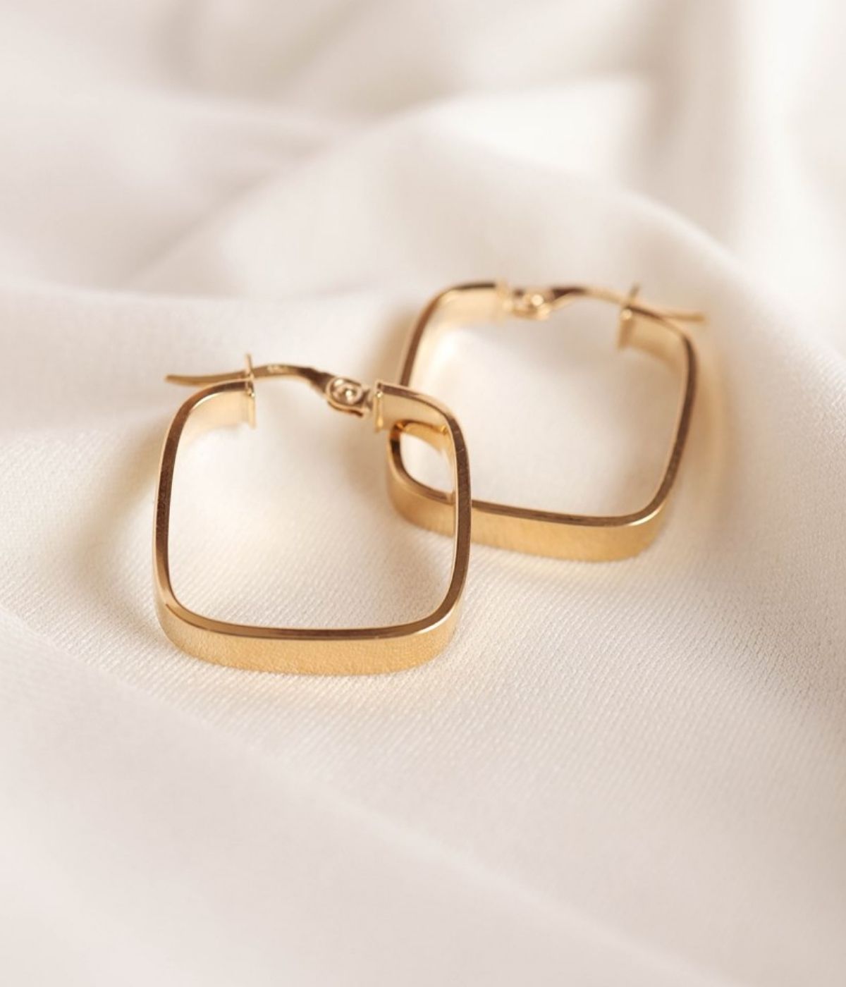 עגילי חישוק זהב 14K בצורת ריבוע בעיצוב מודרני, חישוקים עבים ומבריקים עם מראה גיאומטרי נקי ואלגנטי.