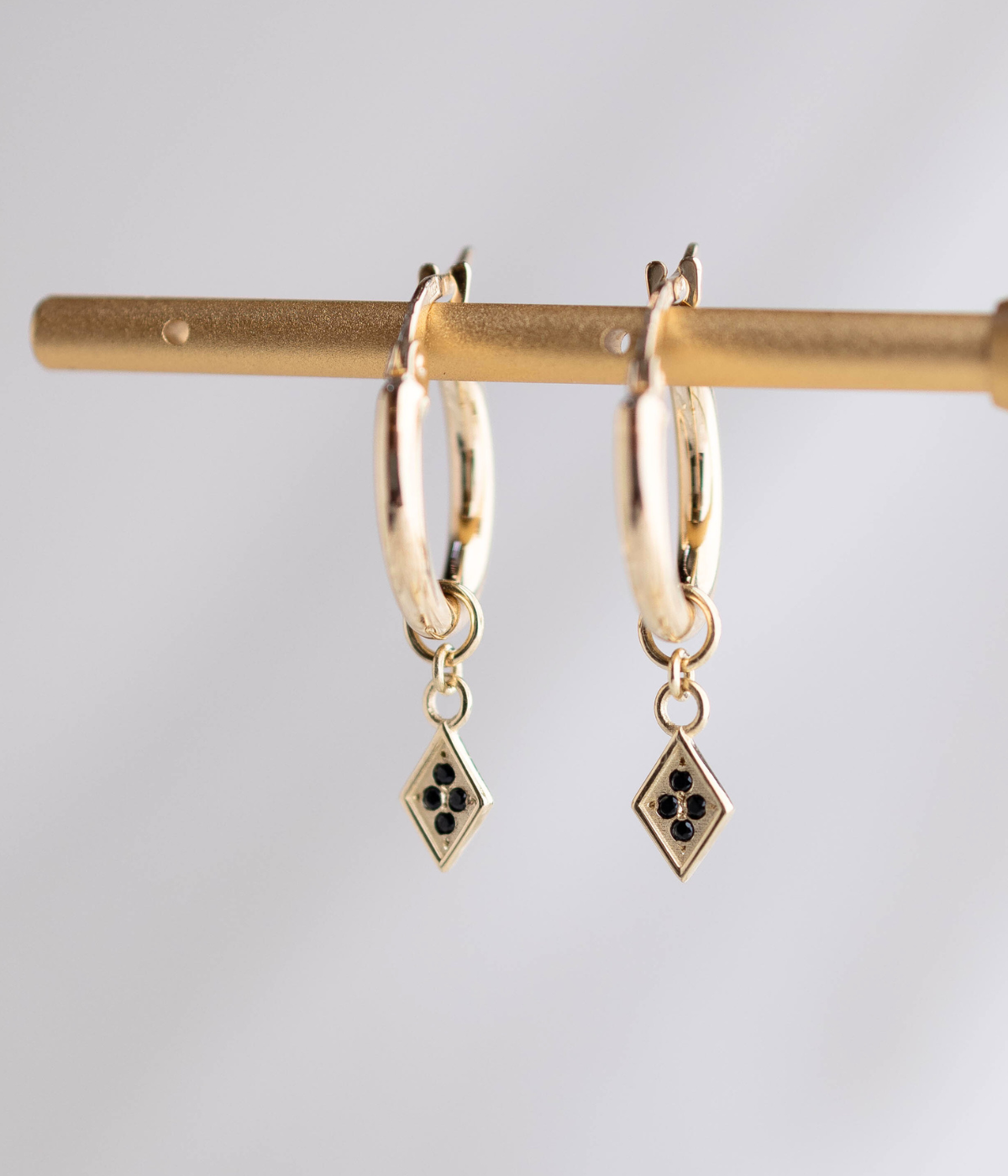 עגילי חישוק זהב 14K עם תליון מעויין משובץ יהלומים שחורים, בעיצוב גיאומטרי אלגנטי ומוקפד