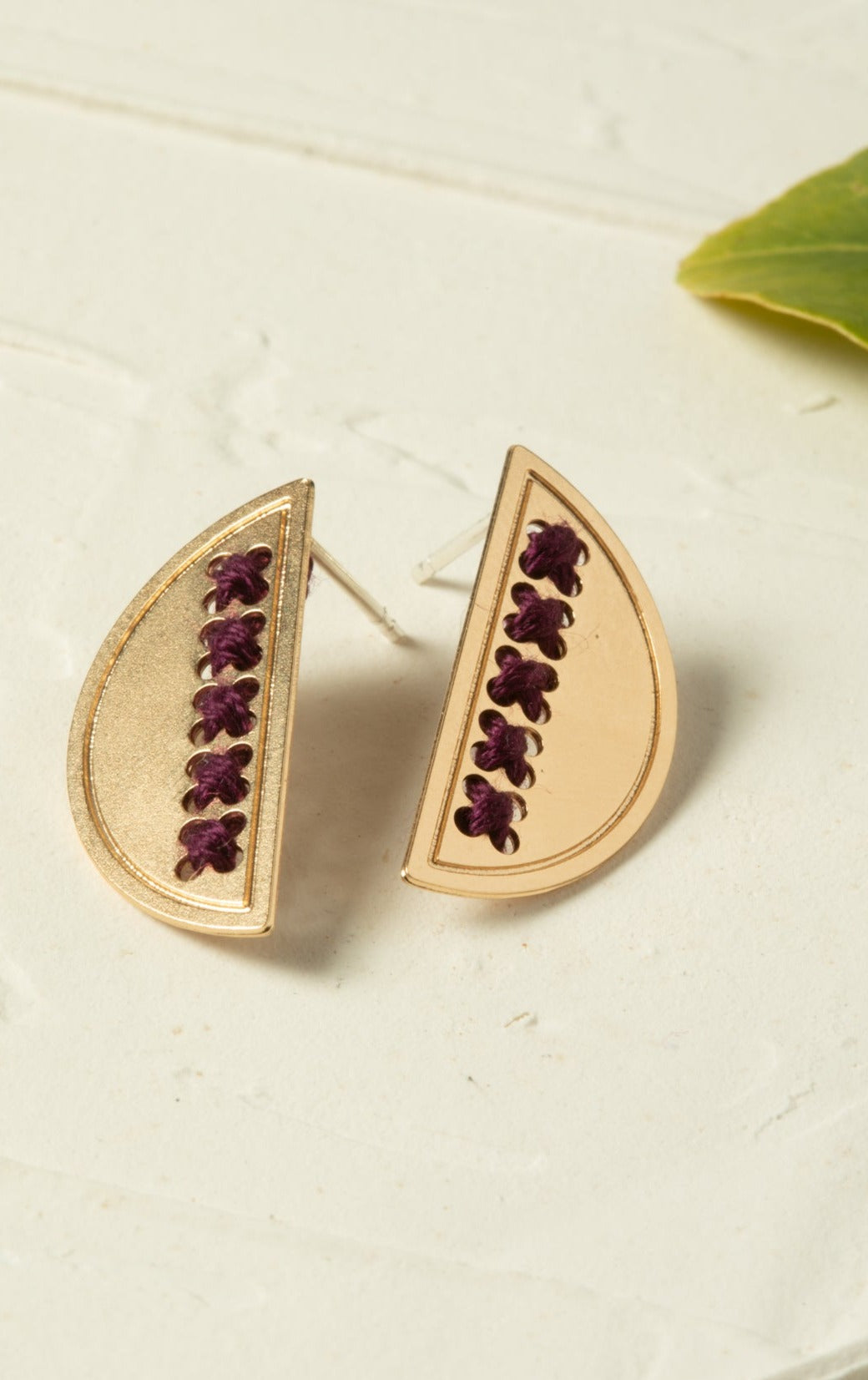 עגיל חצי עיגול עם רקמה בעבודת יד, תלוי על האוזן, בעיצוב אומנותי ועדין.