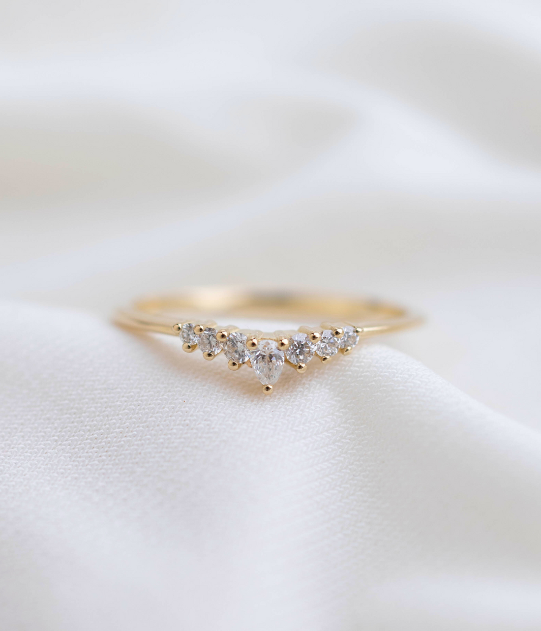 טבעת זהב 14K בשיבוץ יהלומים טבעיים, כולל יהלום מרכזי בצורת טיפה עם שישה יהלומים משובצים ככתר.