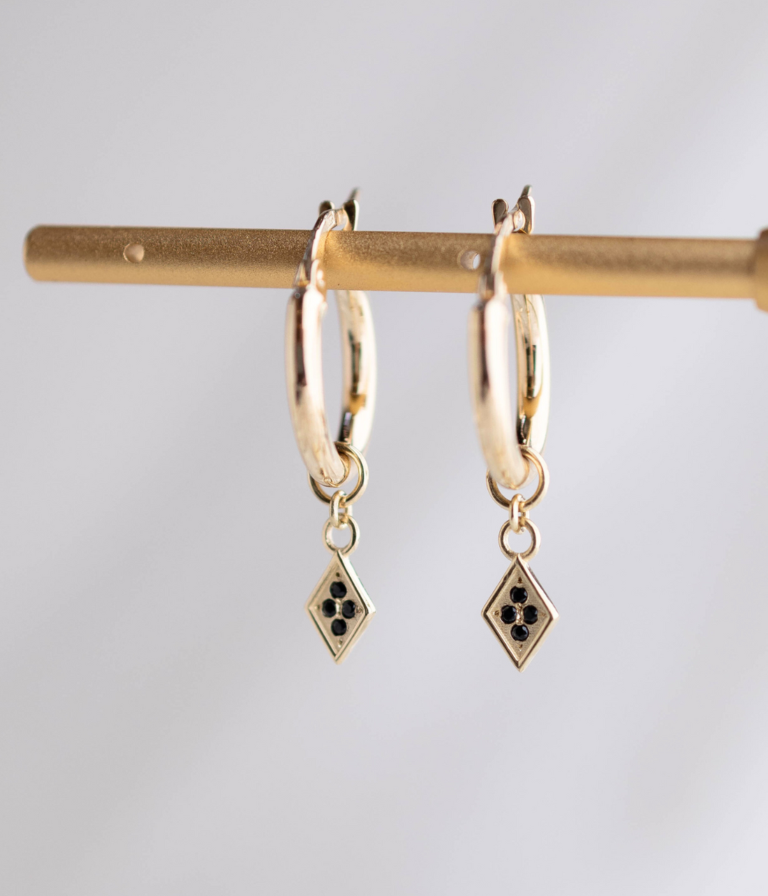 עגילי חישוק זהב 14K עם תליון מעויין משובץ יהלומים שחורים, בעיצוב גיאומטרי אלגנטי ומוקפד