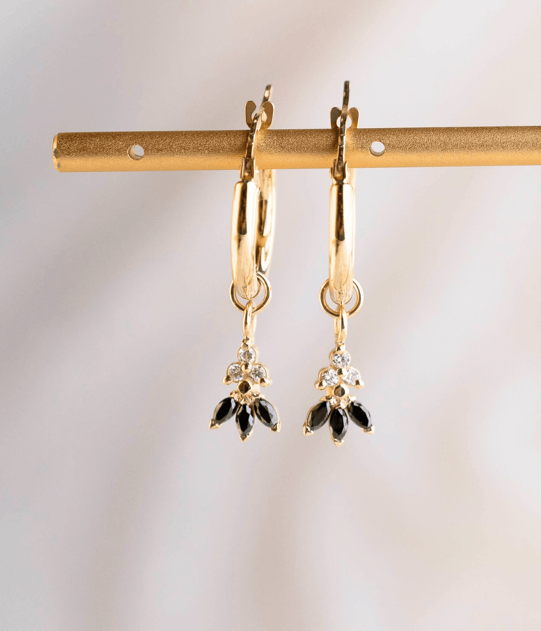 עגילי חישוק לוטוס מזהב 14K עם תליון לוטוס משובץ יהלומים שחורים ויהלומים טבעיים, בעיצוב יוקרתי ואלגנטי.