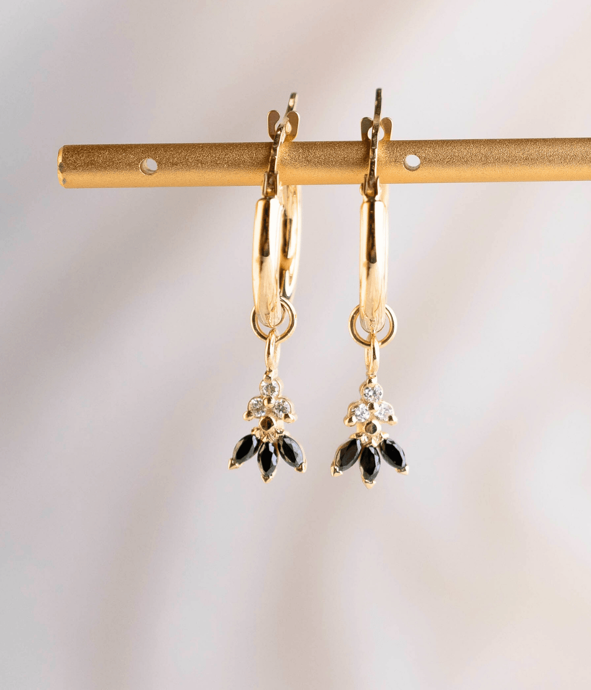 עגילי חישוק לוטוס מזהב 14K עם תליון לוטוס משובץ יהלומים שחורים ויהלומים טבעיים, בעיצוב יוקרתי ואלגנטי.