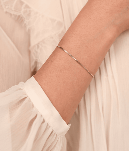 צמיד זהב 14K עדין בעיצוב קוביות קטנות, מראה נקי ואלגנטי על פרק כף היד.