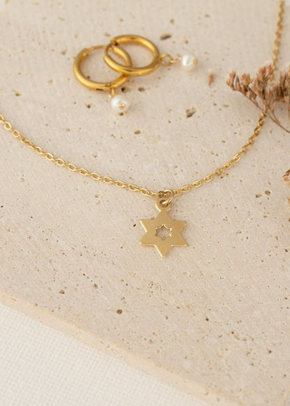 סט תכשיטים עדין הכולל שרשרת דו־צדדית עם תליון מגן דוד בתוך מגן דוד בציפוי זהב ועגילי חישוק עם פנינה קלאסית, בעיצוב נשי ועל־זמני