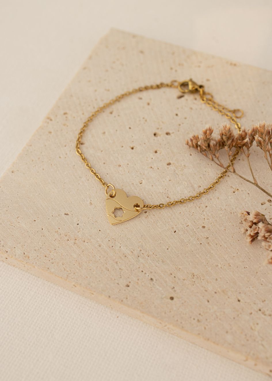 צמיד עדין עם תליון דו־צדדי – לב בציפוי זהב, צד אחד עם אזכור לדגל ישראל וצד שני מגן דוד בתוך הלב, בעיצוב נשי ועל־זמני