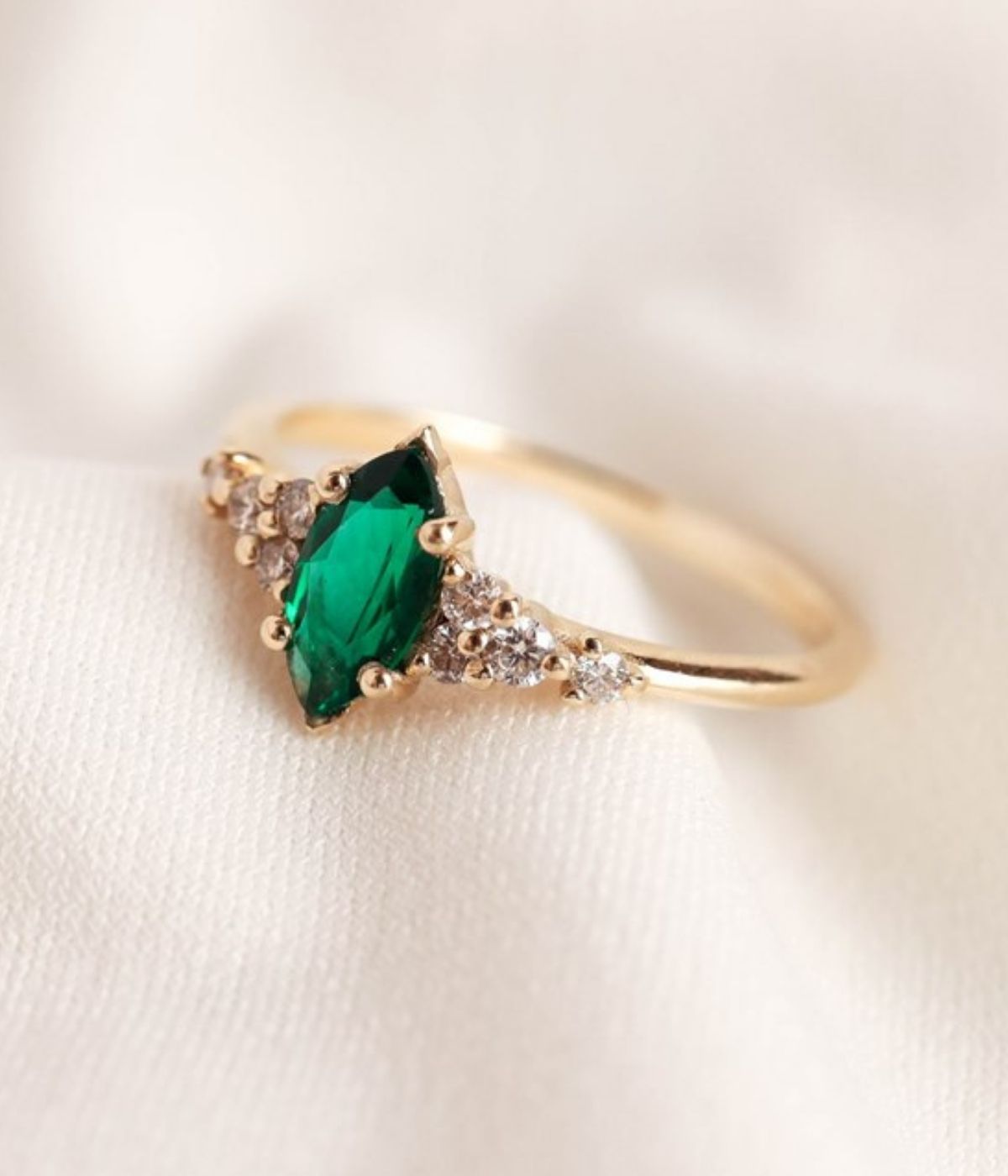 טבעת זהב 14 קראט בעיצוב מלכותי עם אבן חן בצורת מרקיזה במרכז ושיבוץ יהלומים טבעיים משני הצדדים