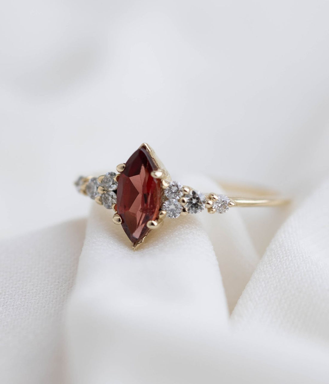 טבעת זהב 14 קראט בעיצוב מלכותי עם אבן חן בצורת מרקיזה במרכז ושיבוץ יהלומים טבעיים משני הצדדים