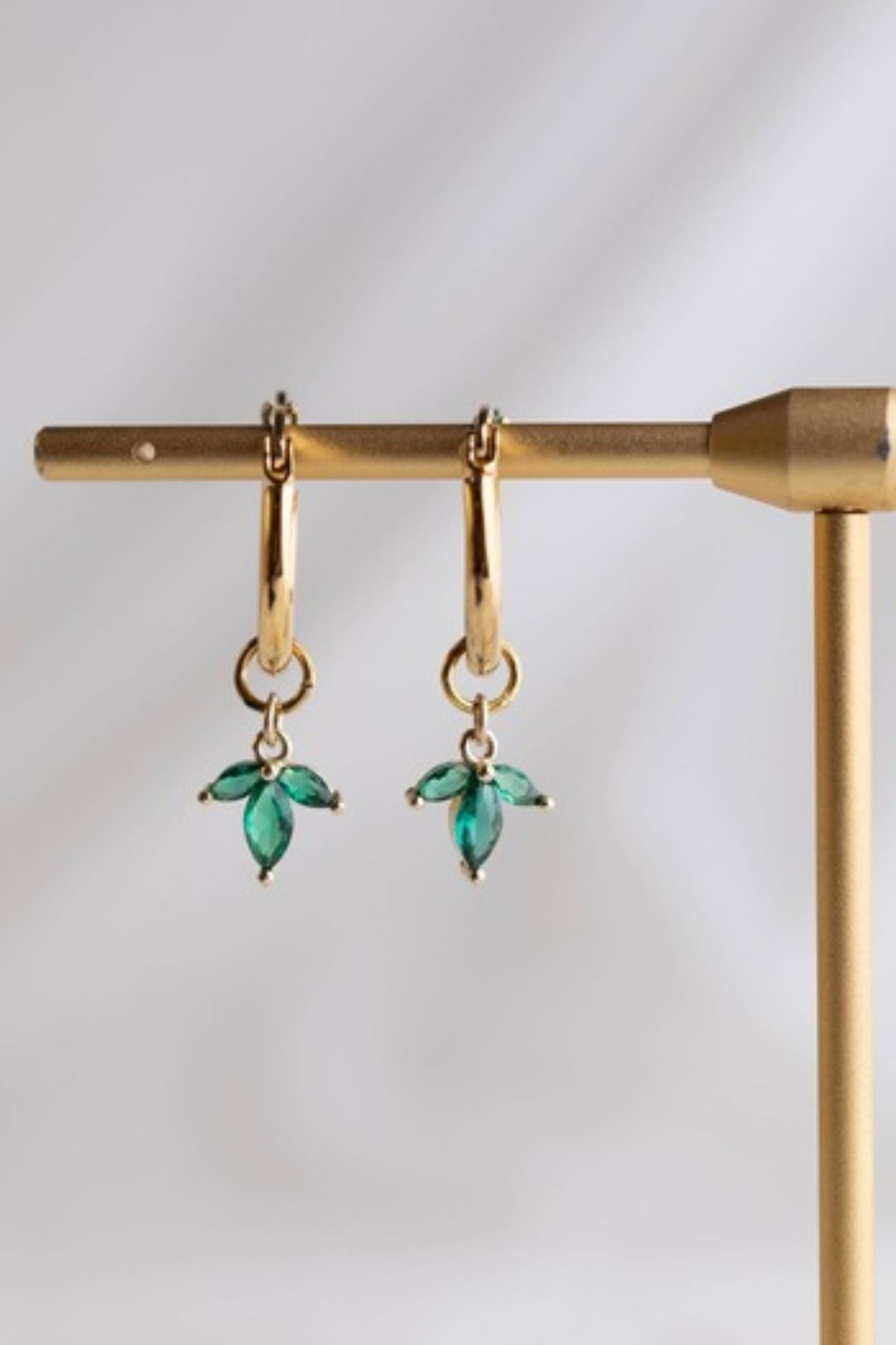 עגילי חישוק קטנים בציפוי זהב עם תליון פרח לוטוס וזירקונים ירוקים בעיצוב עדין עם תנועה