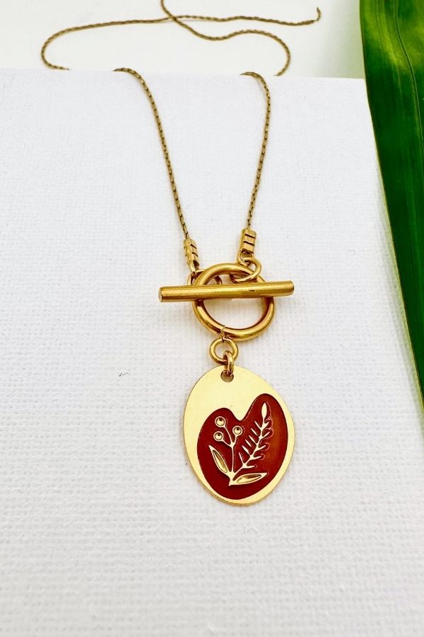 שרשרת דו צדדית בגוון אדמה עם סוגר קדמי ותליון אובל א־סימטרי, חריטת פריחה בצד אחד ושמש וירח בצד השני