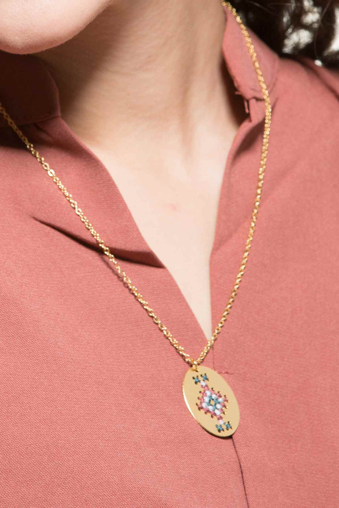 שרשרת עדינה עם תליון רקום בעבודת יד ברקמת איקסים על גבי מתכת, עיצוב אתני ואצילי.