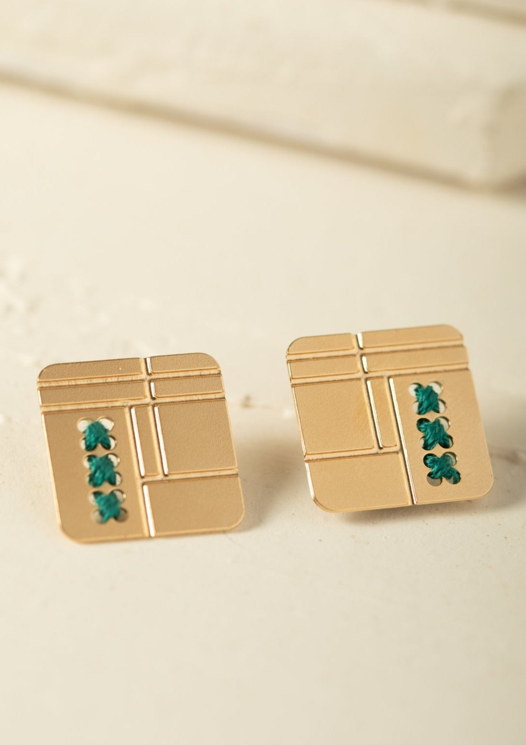 עגיל מרובע עם פינות מעוגלות ורקמות בעבודת יד, עדין ומלא נוכחות, אומנותי ומיוחד.