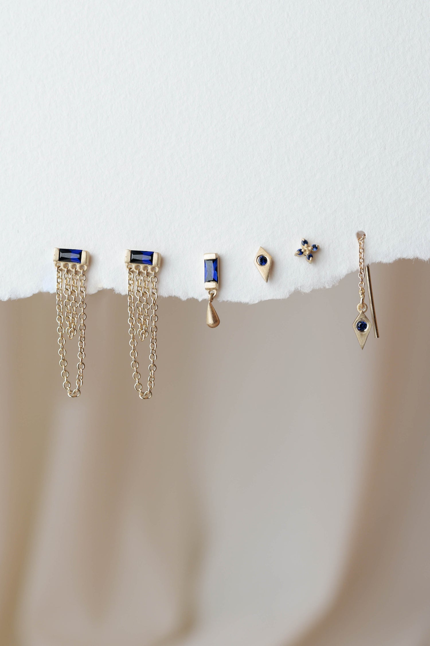 סט עגילי זהב עם אבני ספיר בעיצובים שונים ליצירת שילובים אלגנטיים ומודרניים