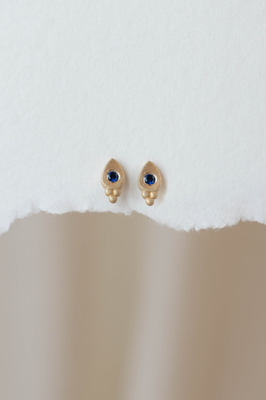 עגיל זהב עם ספיר כחול עגול בצורת טיפה, קטן ומינימליסטי