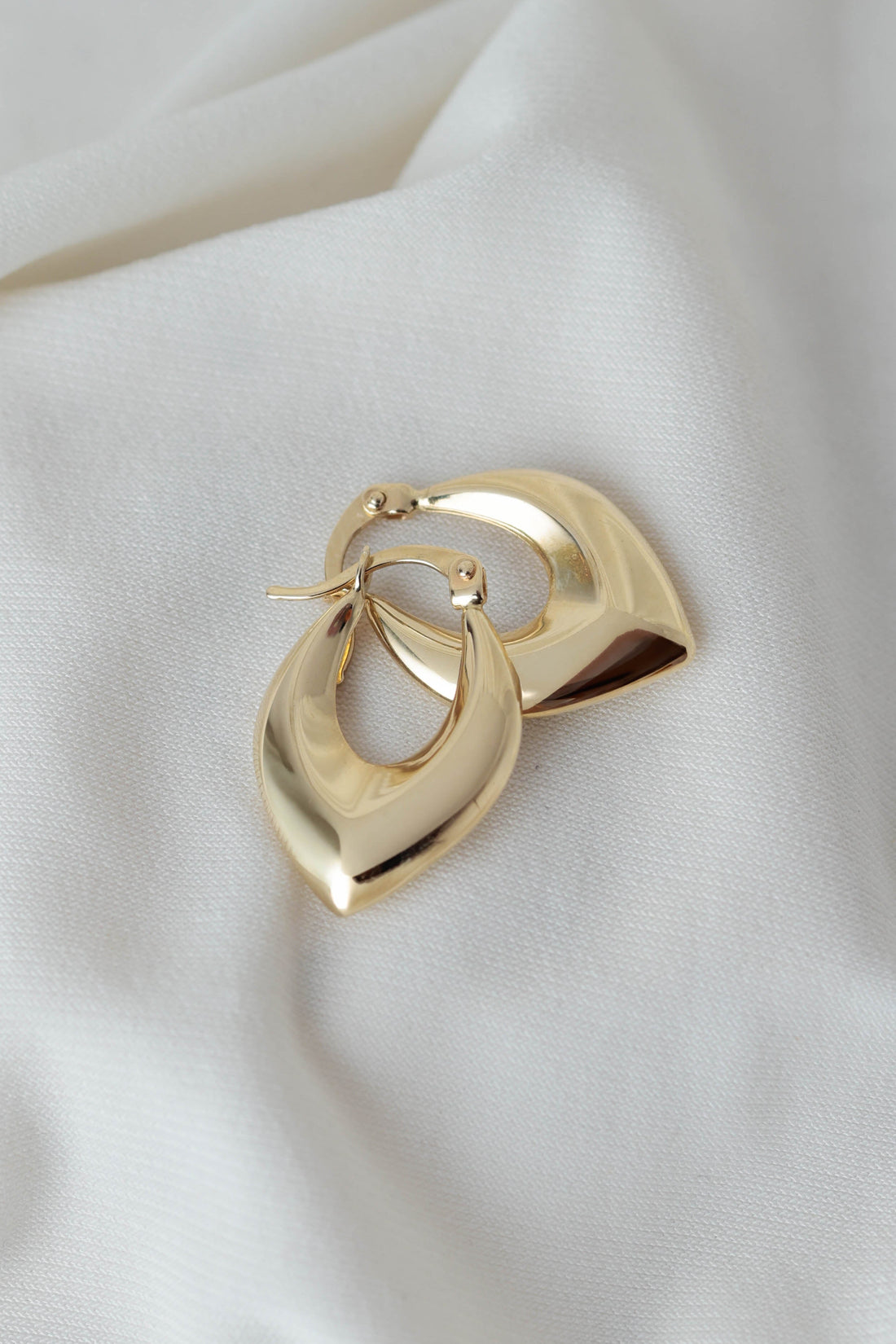 עגילי זהב בעיצוב טיפה פתוחה עם קווים רכים ונוכחות אלגנטית.