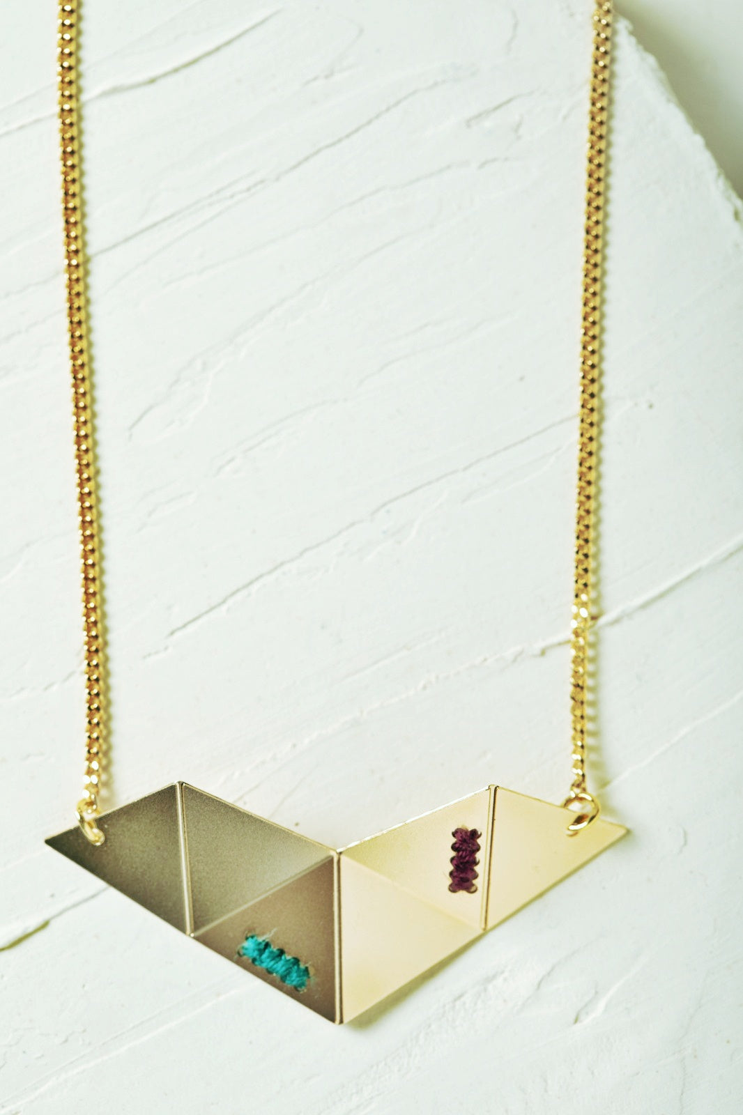 שרשרת קיפולי אוריגמי עם קיפולי מתכת גאומטריים ורקמה בעבודת יד.