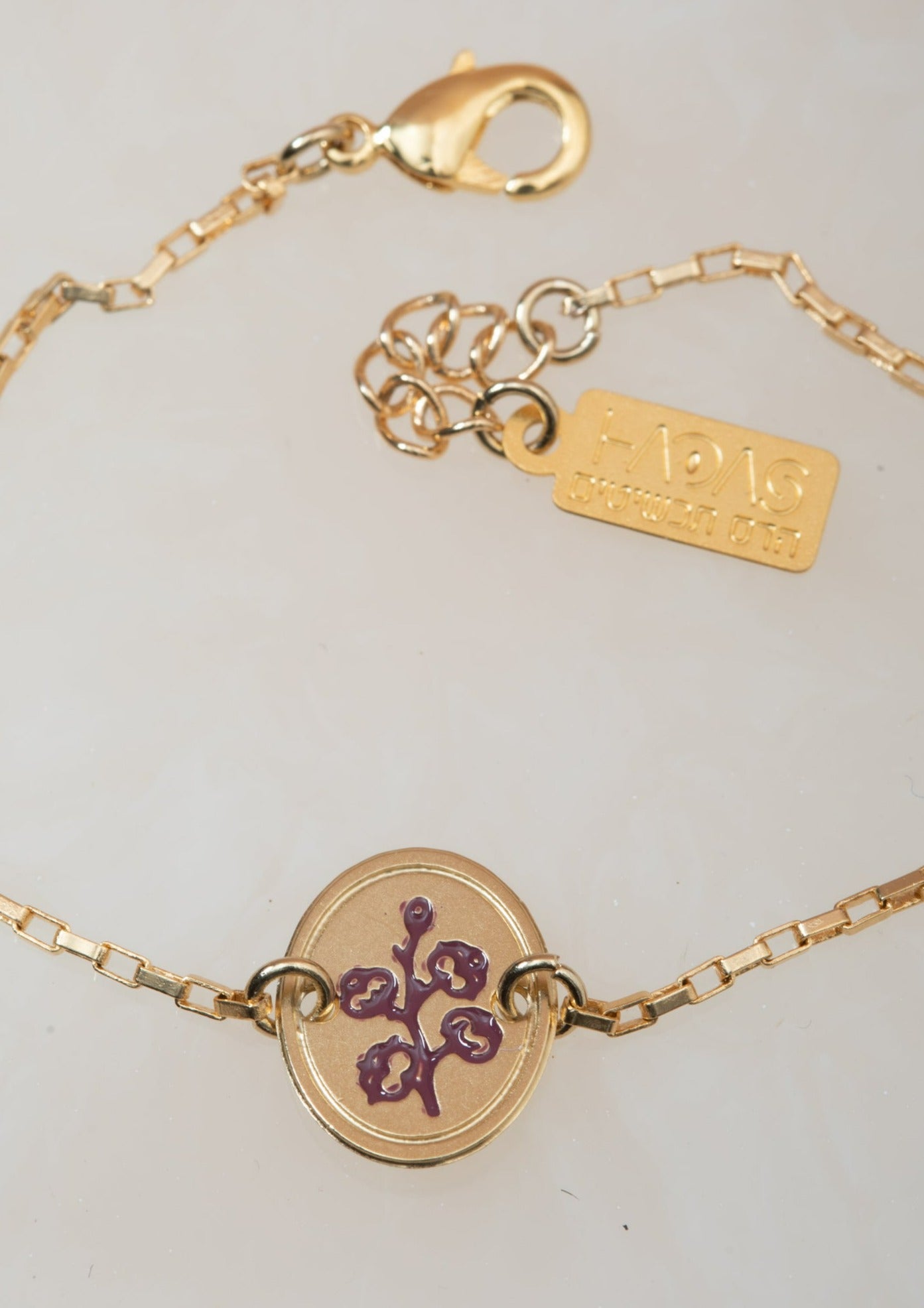 צמיד כותנה עם חריטה של פרח כותנה בצבע סגול וחריטת המילים &