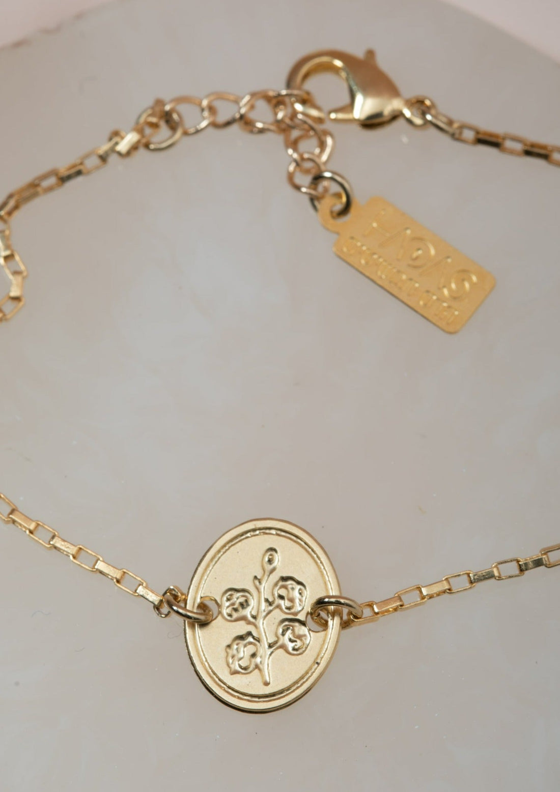 צמיד כותנה עם חריטה של פרח כותנה ובצד השני חריטת &